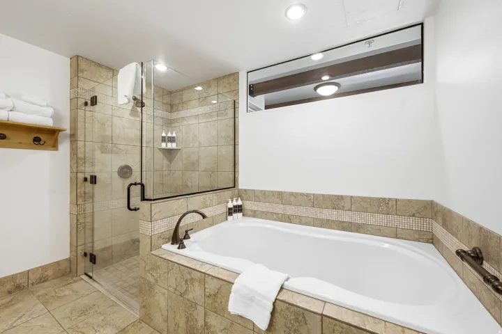 Tile-surrounded soaking tub with bronze-finish fixtures