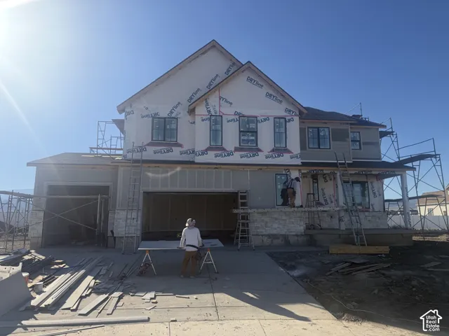 Two-story residential structure featuring a multi-gabled roofline, stone veneer foundation accents, and dark-framed windows