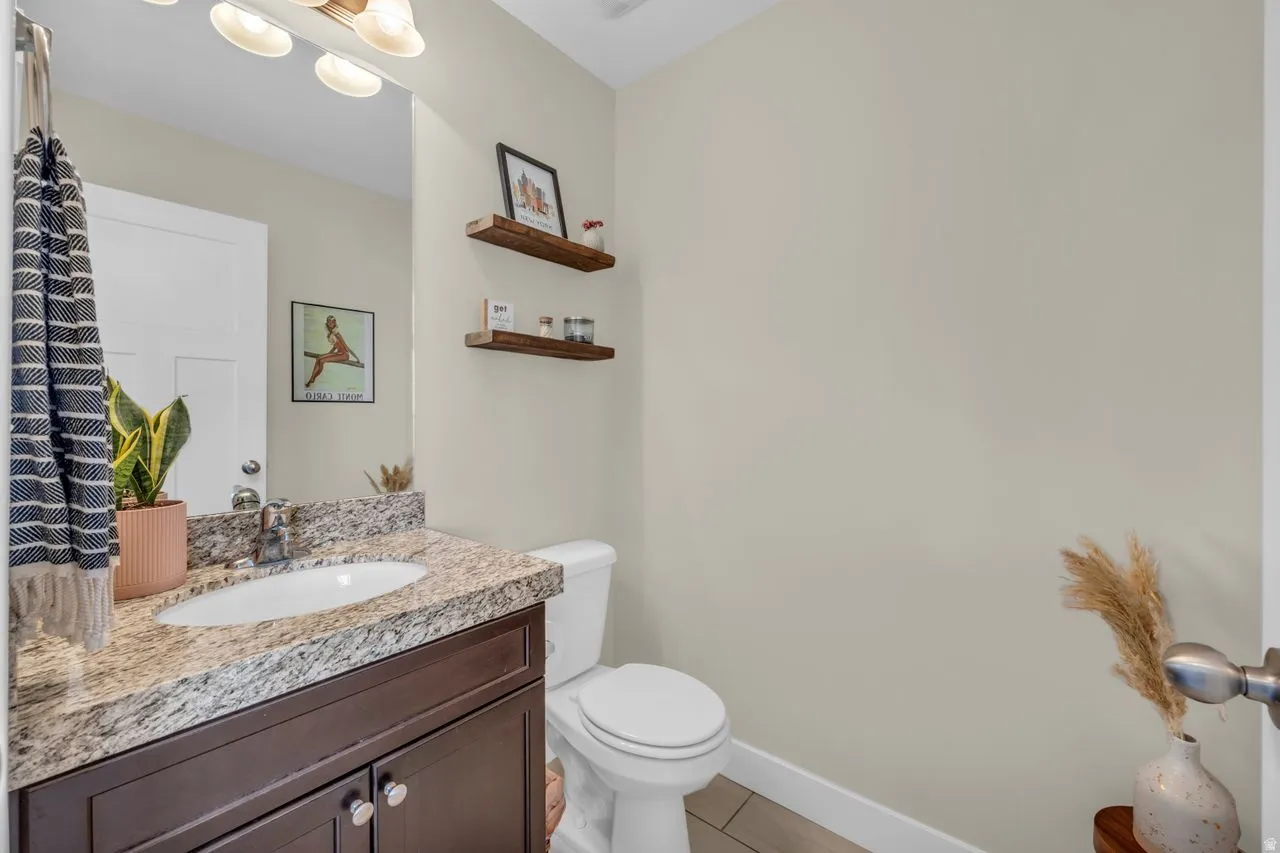 Vanity with granite countertop, integrated sink, and dark wood-finish cabinetry