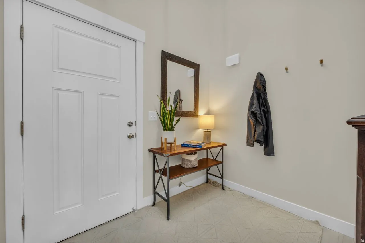 White paneled door with brushed nickel hardware, neutral wall color, and light-toned flooring