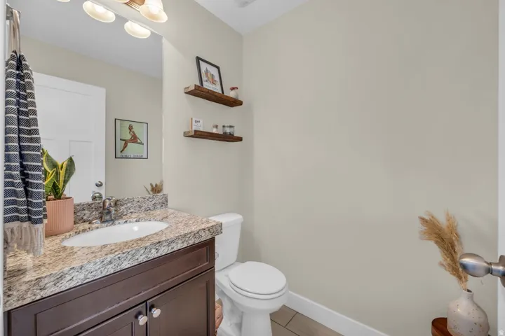 Vanity with granite countertop, integrated sink, and dark wood-finish cabinetry