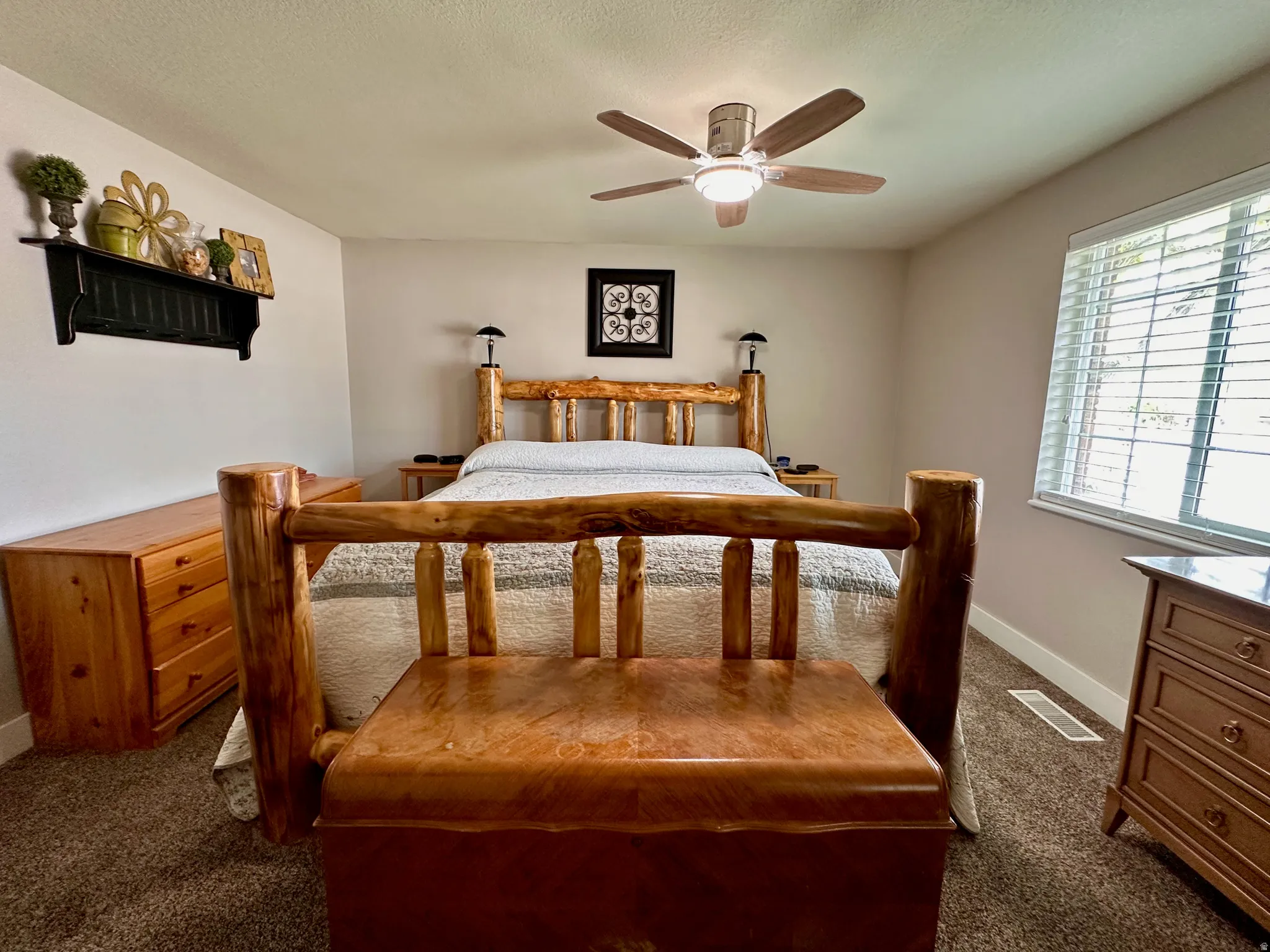 Carpeted room featuring a ceiling fan with integrated lighting, a window with horizontal blinds, and neutral wall paint