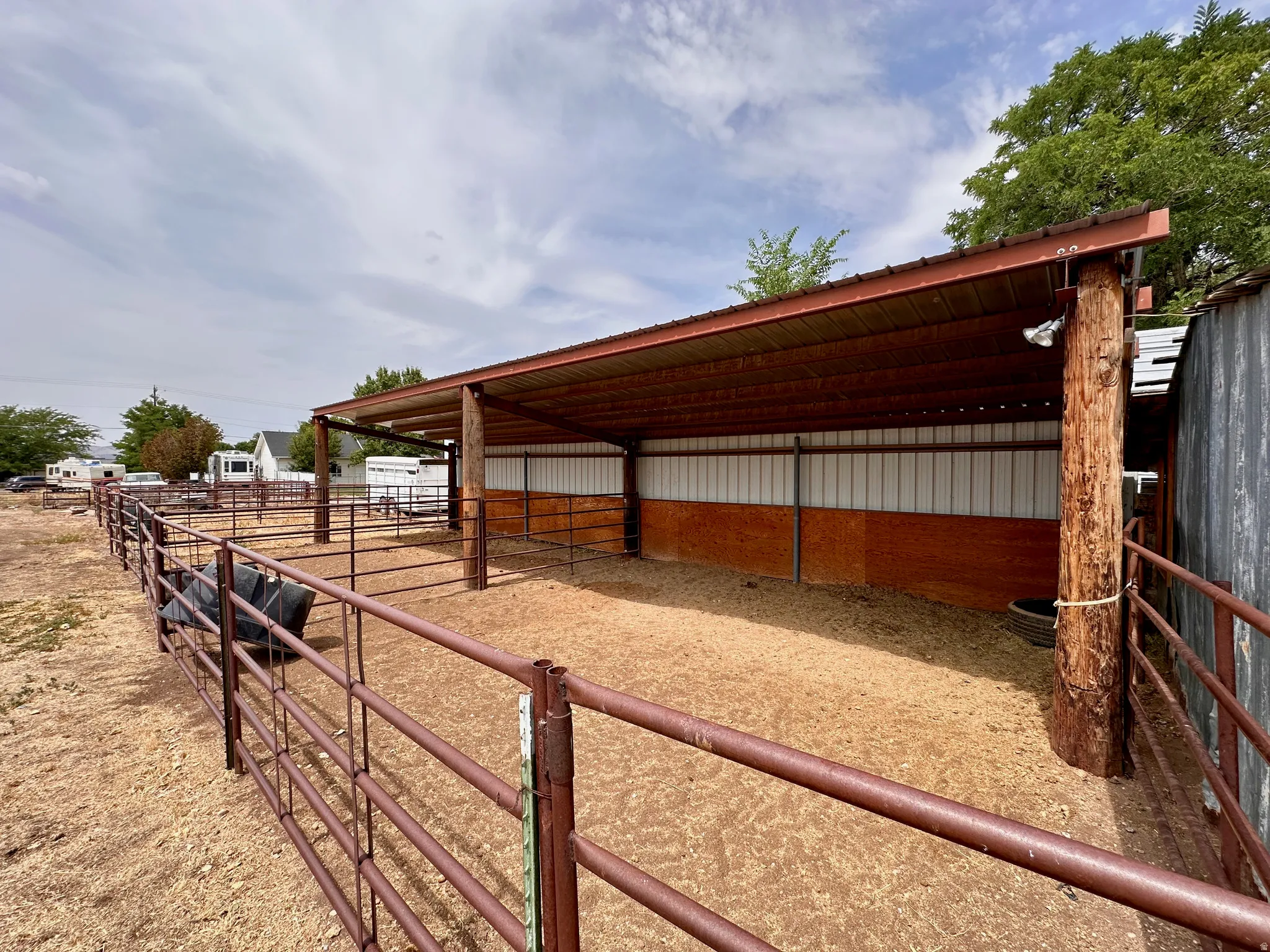 Covered animal enclosure with metal fencing and wood-paneled walls