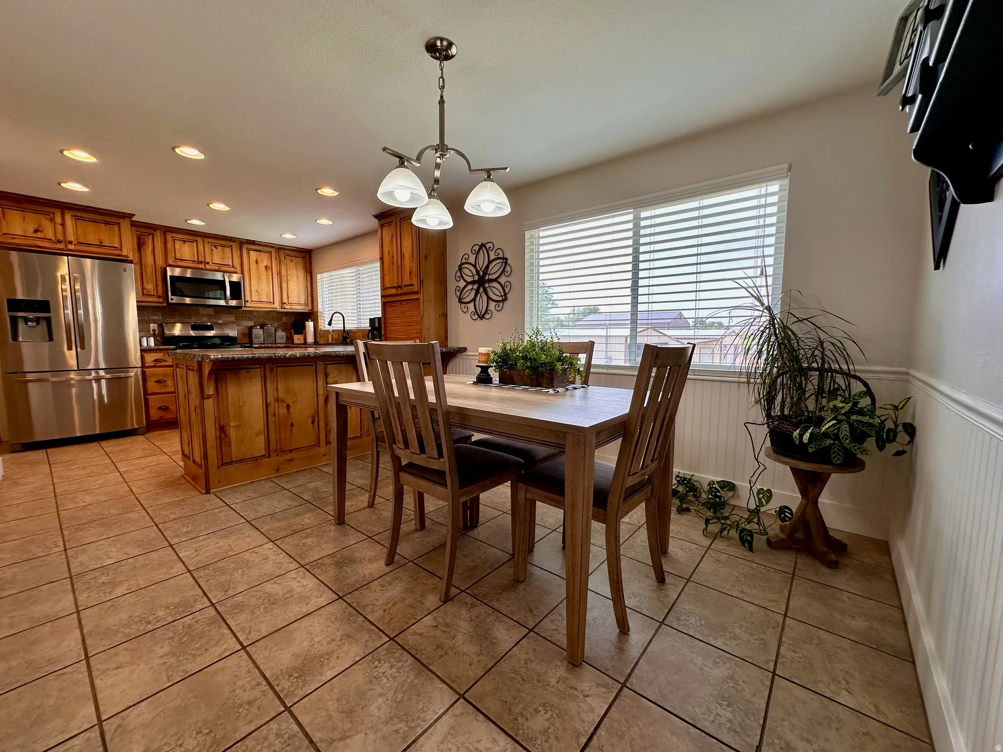 Kitchen featuring wood cabinetry, stainless steel appliances, and an island with counter seating