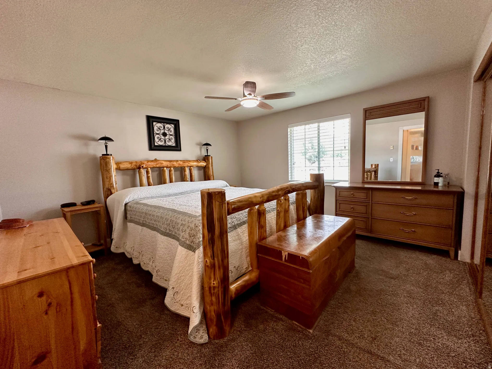 Recessed window with blinds, ceiling fan with integrated lighting, and carpeted flooring