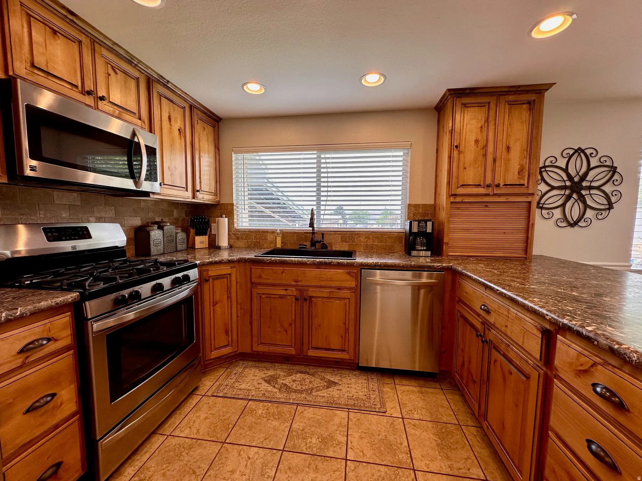 Kitchen featuring wood cabinetry, stainless steel appliances, recessed lighting, and tile flooring