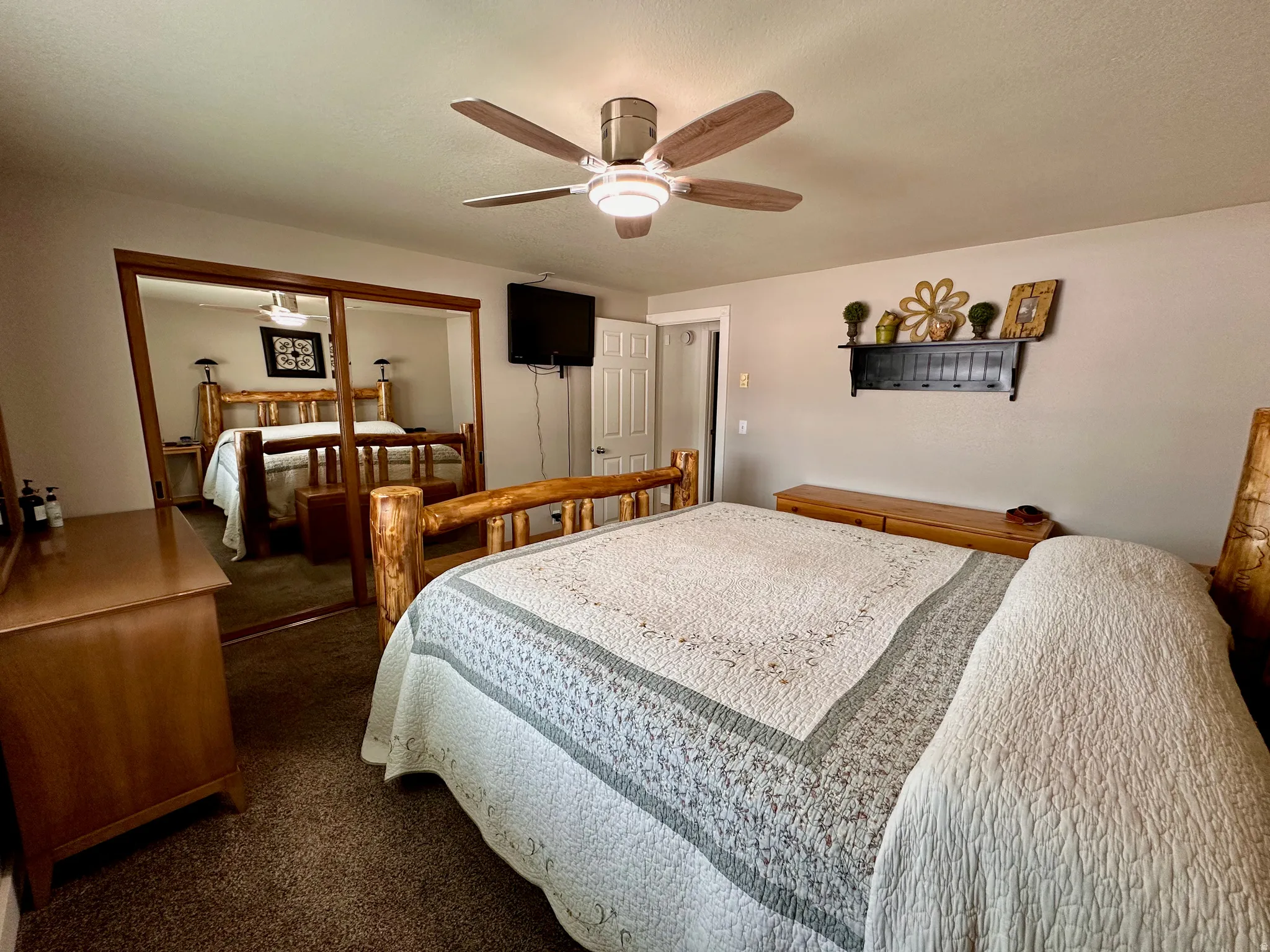 Recessed lighting, wood-finish ceiling fan, mirrored closet doors with wood trim, and textured carpeting