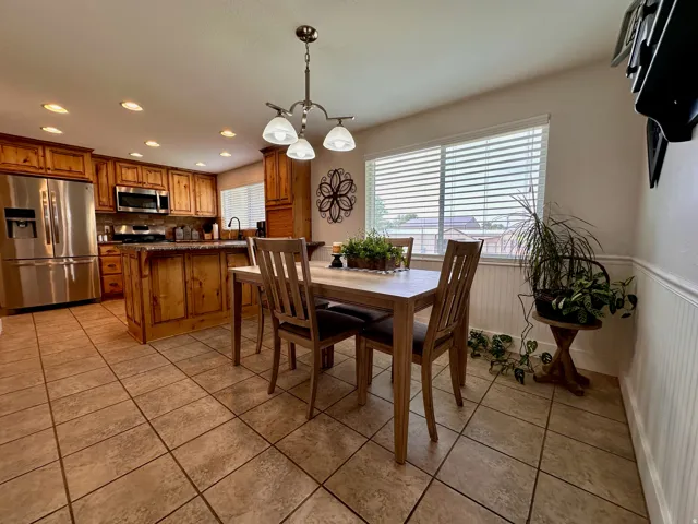 Kitchen featuring wood cabinetry, stainless steel appliances, and an island with counter seating