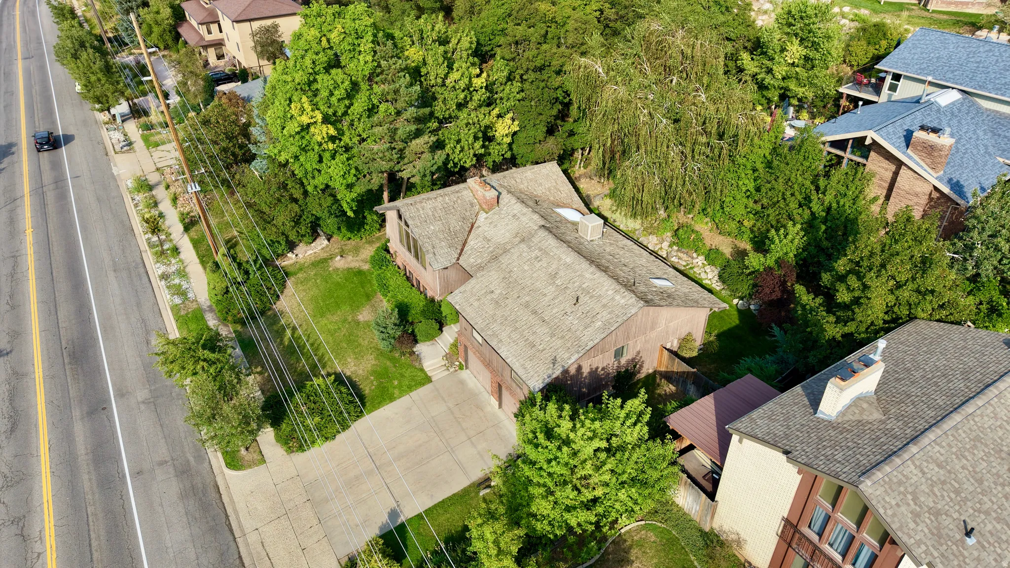Property with a concrete driveway, attached garage, and a sloped roof