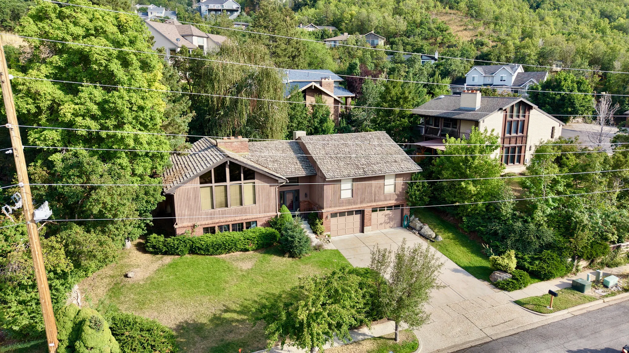Split-level residence featuring a multi-pane bay window, attached two-car garage, and a sloped shingle roof