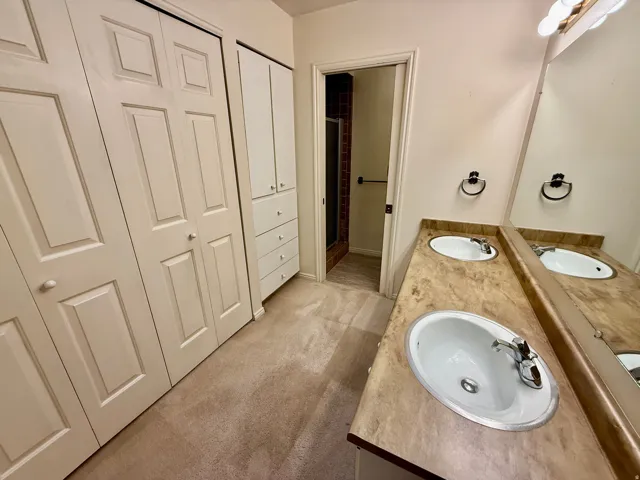 Master Bathroom with his and her closets, double vanity, and walk-in shower.