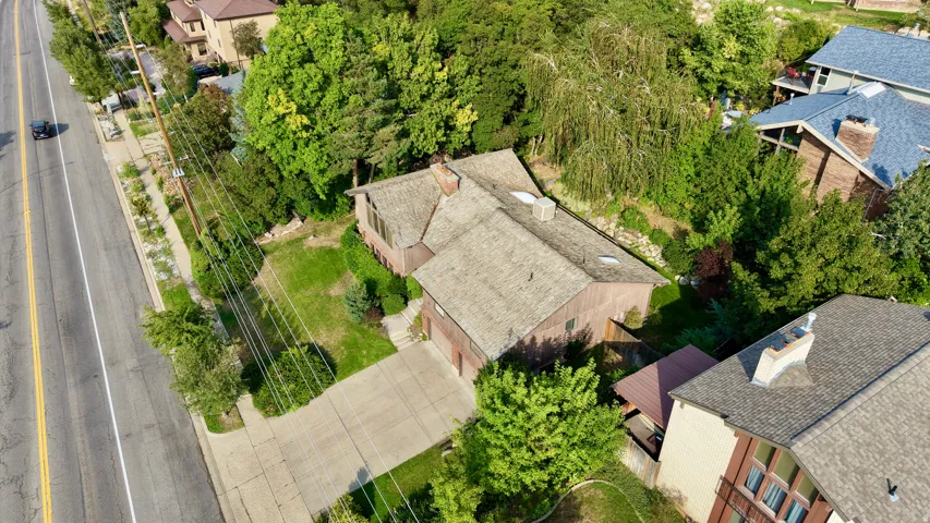 Property with a concrete driveway, attached garage, and a sloped roof