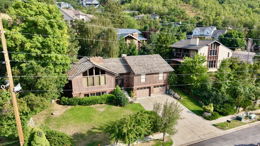 Split-level residence featuring a multi-pane bay window, attached two-car garage, and a sloped shingle roof