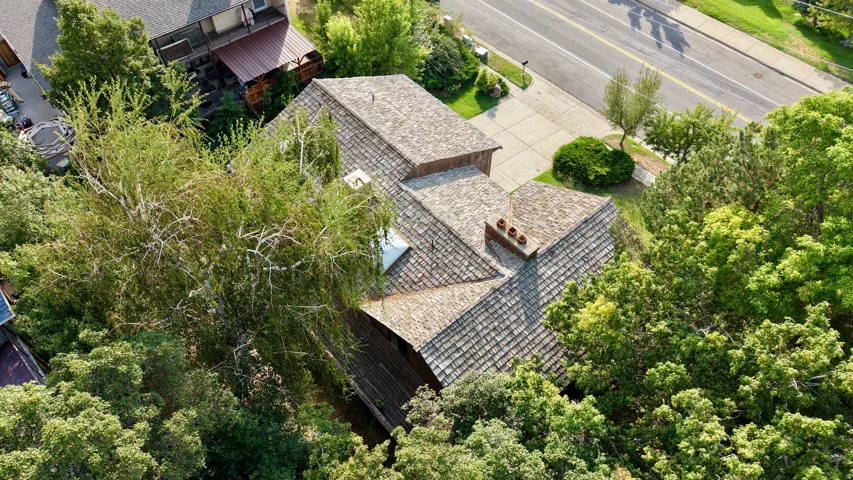 Cedar shake roof with multiple gables and a brick chimney