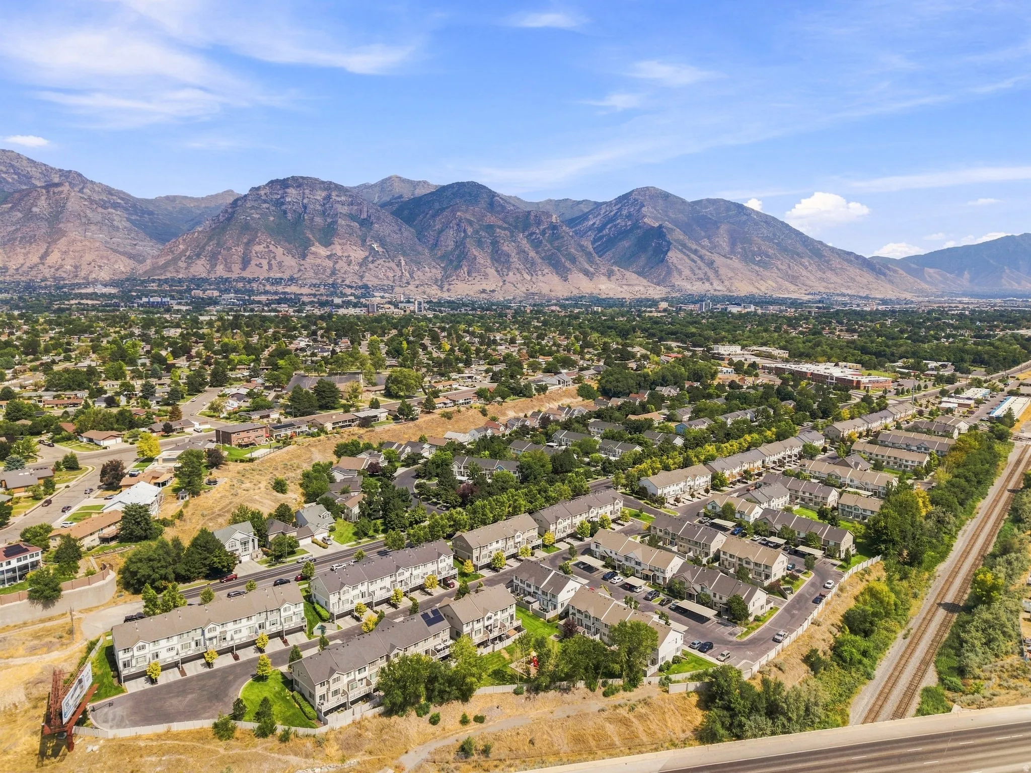 Townhome community with mountain scenery, mature trees, and nearby railway access