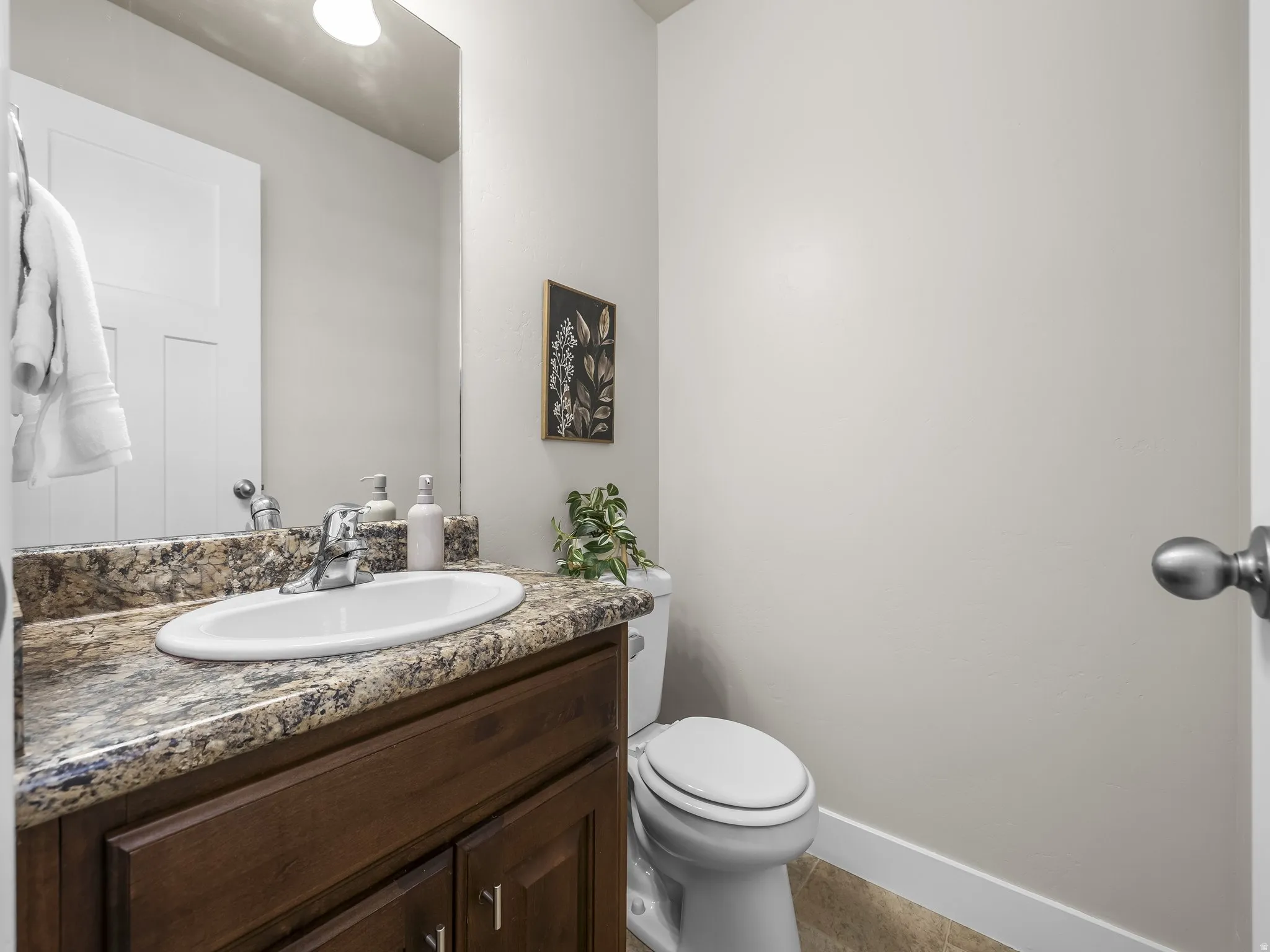 Built-in vanity with a granite-style countertop, undermount sink, and dark wood-finish cabinetry