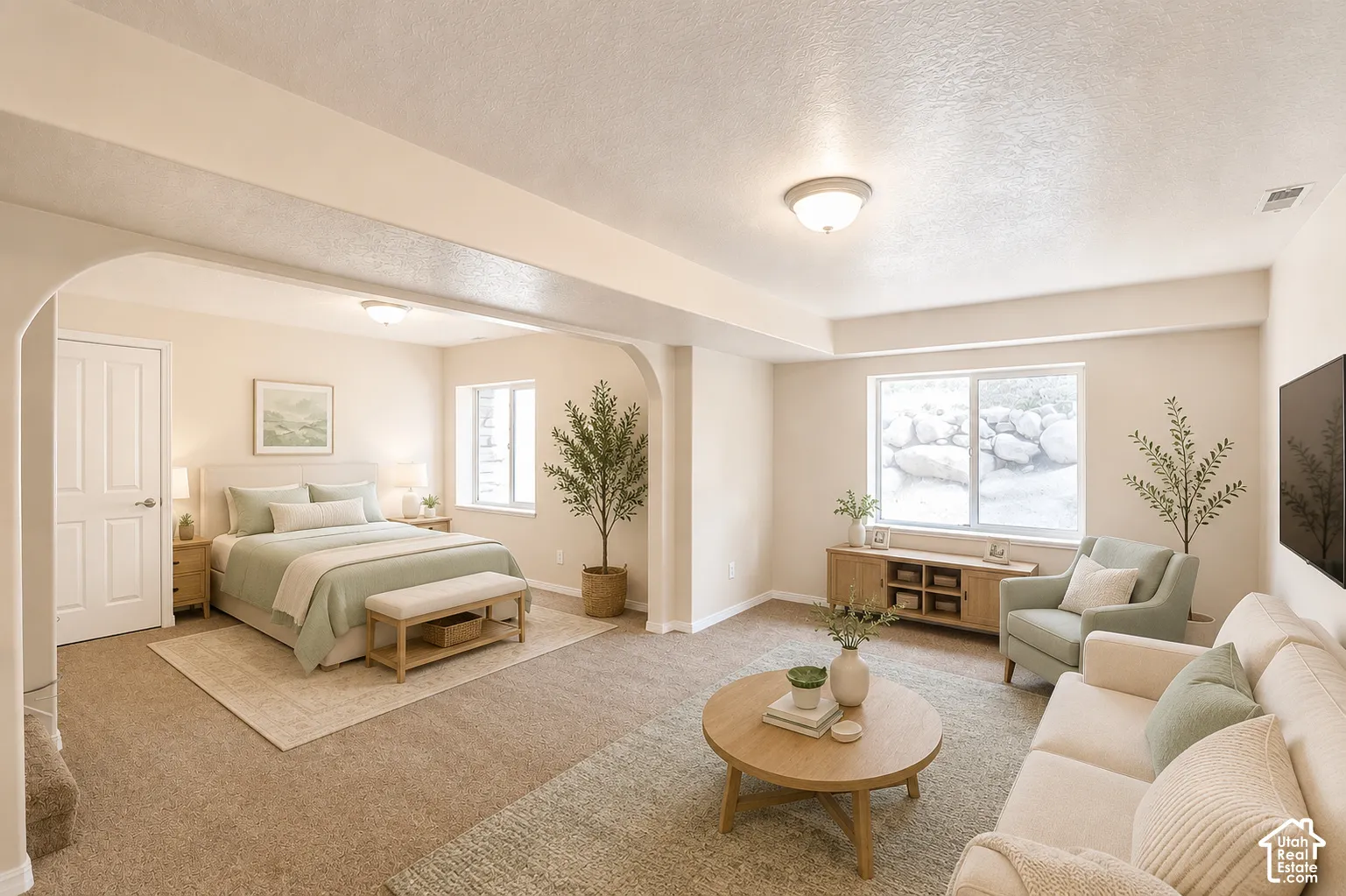 Expansive open-concept room featuring warm-toned walls, recessed lighting, and carpet flooring