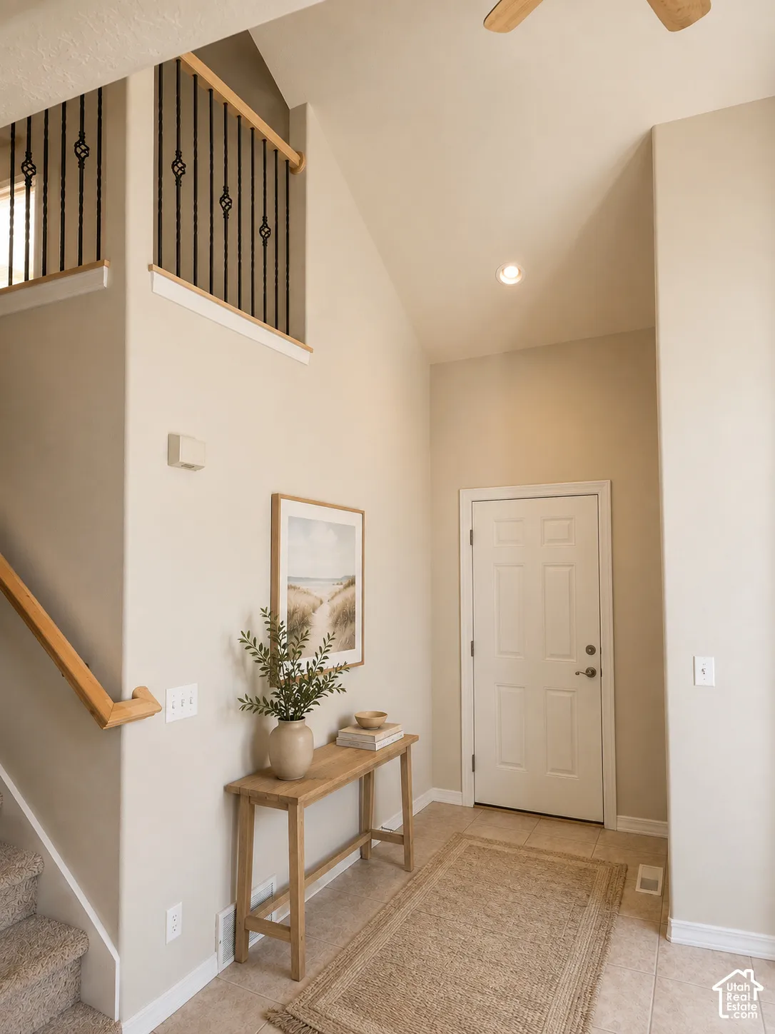Vaulted ceiling foyer featuring a paneled entry door, recessed lighting, and tile flooring