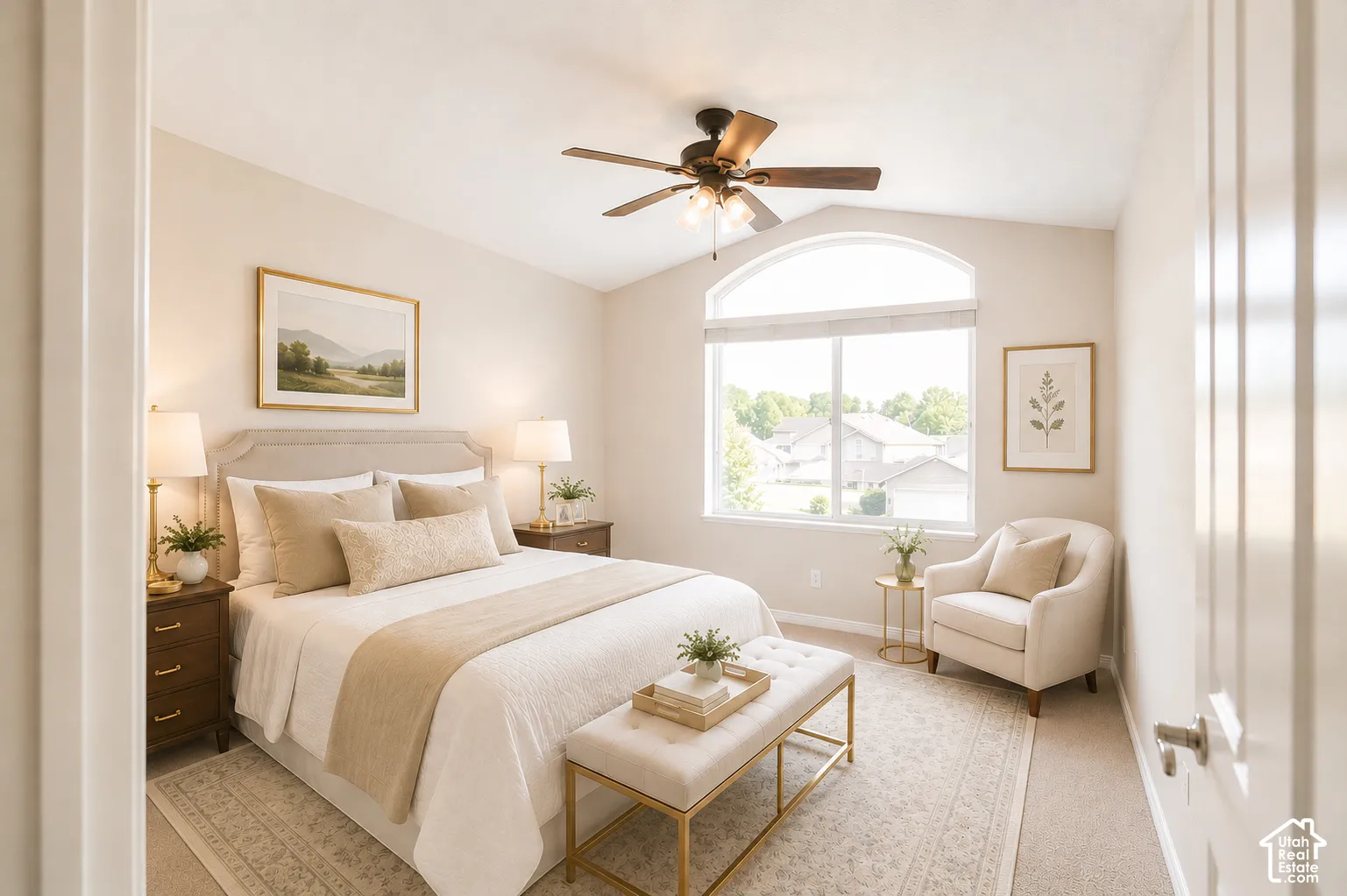 Serene primary bedroom showcasing a curved headboard bed, dual bedside tables with integrated lighting, an arched transom window with natural light, ceiling fan with brass finish, and neutral tonal palette throughout
