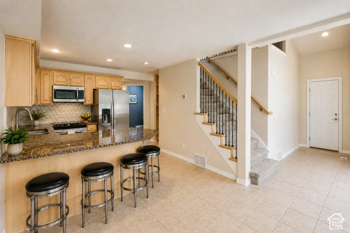 Kitchen featuring wood cabinetry, stainless steel appliances, and a granite-finish countertop
