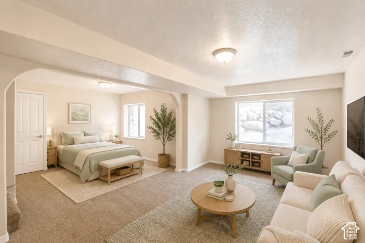 Expansive open-concept room featuring warm-toned walls, recessed lighting, and carpet flooring