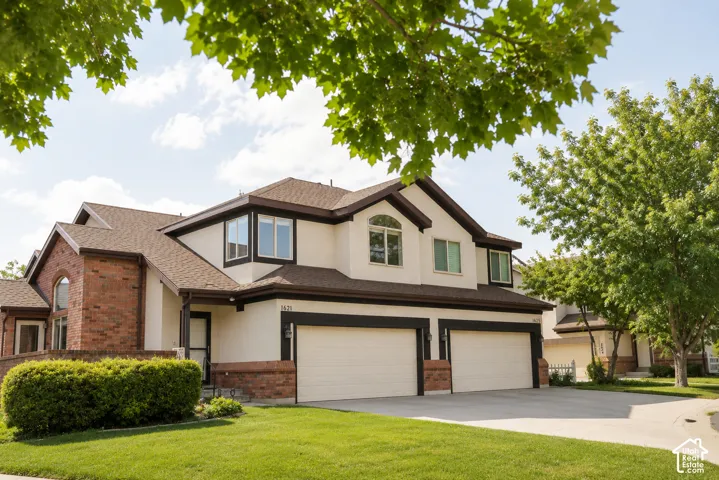 Brick and stucco exterior with multiple gables and a two-car garage
