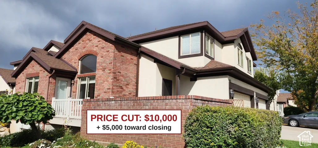Brick and stucco exterior with multiple gables, arched window detail, and an attached garage