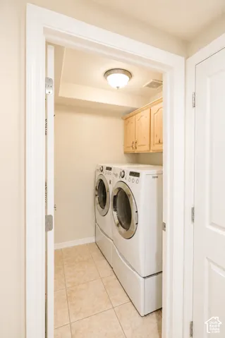Laundry area with tile flooring and built-in wood cabinetry