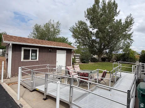 Accessible outdoor entertaining space featuring a metal-ramp entry, aluminum railings, and a composite deck platform