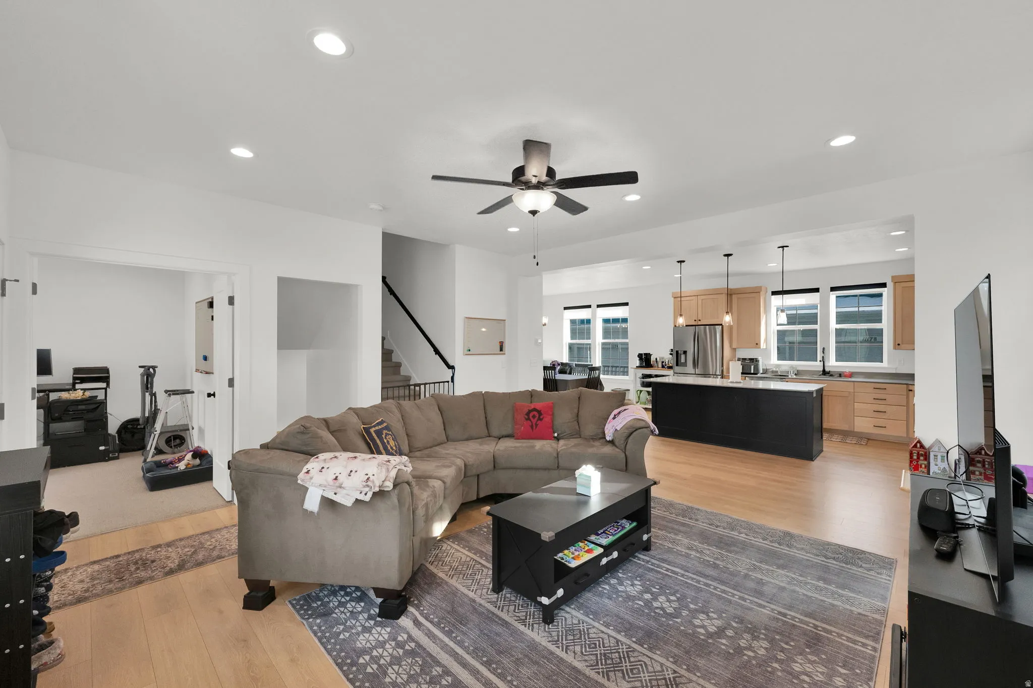 Open-concept living area featuring wood-finish flooring, recessed lighting, and a ceiling fan