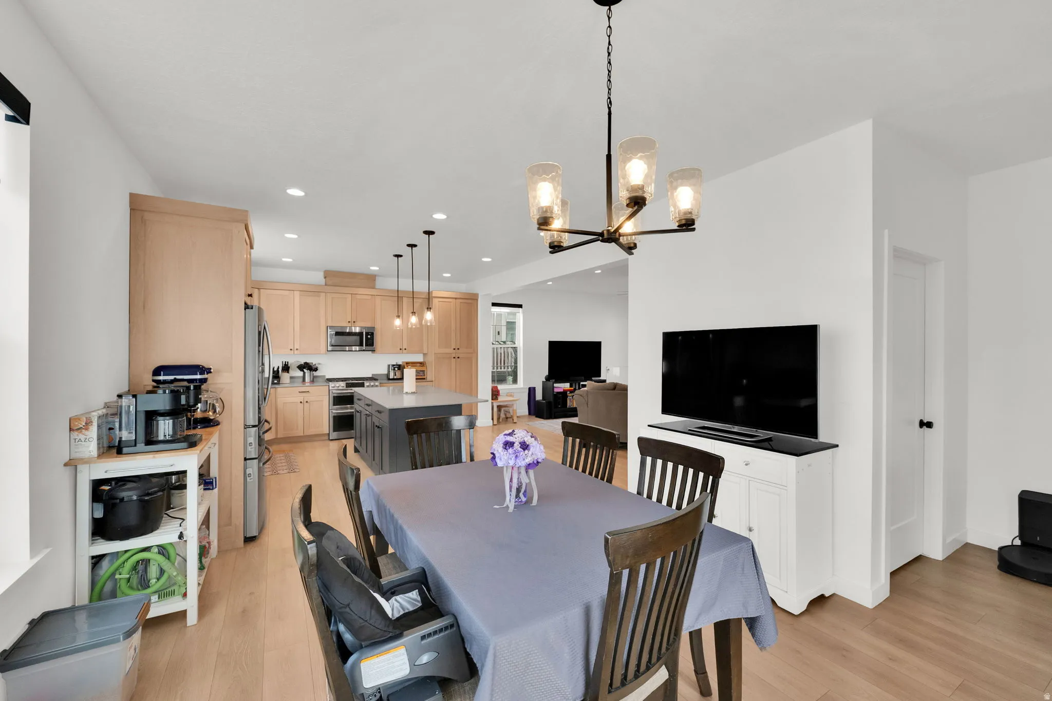 Dining area with a multi-light chandelier, wood-finish flooring, and a white interior door