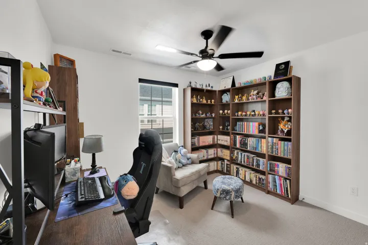Neutral wall colors, recessed window, ceiling fan with integrated lighting, built-in shelving, and carpeting