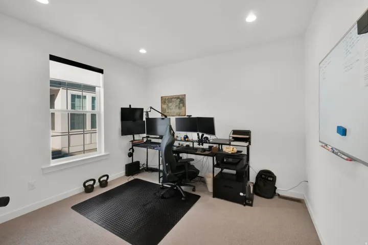 Recessed ceiling lighting, white walls, carpeted flooring, and a double-hung window