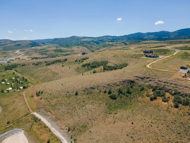 Expansive undeveloped land with distant mountain ranges and scattered trees