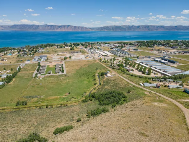 Expansive land parcel with surrounding residential areas, adjacent to a large body of water, with distant mountains