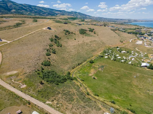 Expansive property with a dirt road, diverse topography, and distant mountains