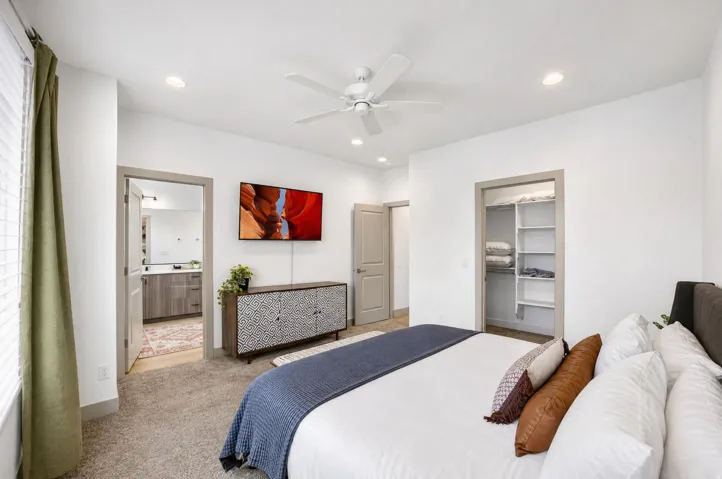 Recessed lighting, ceiling fan, carpet flooring, built-in closet shelving, and wood-finish flooring in adjoining space