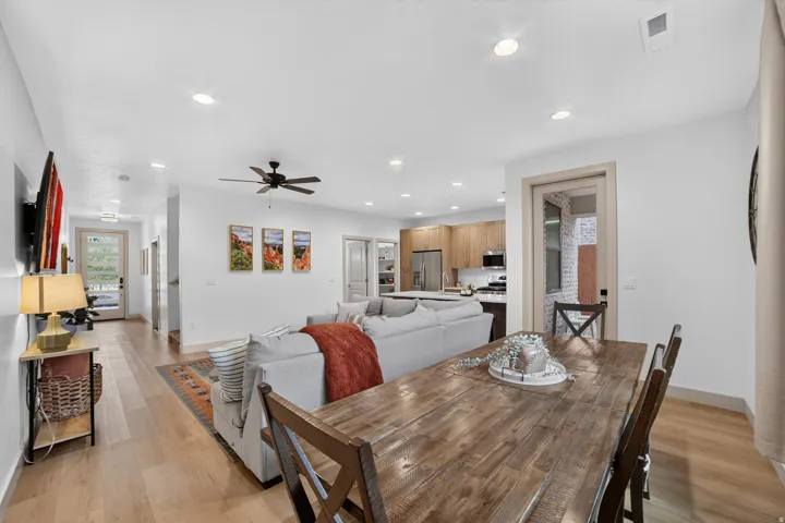 Open-concept living space featuring wood-finish flooring, recessed lighting, and a ceiling fan