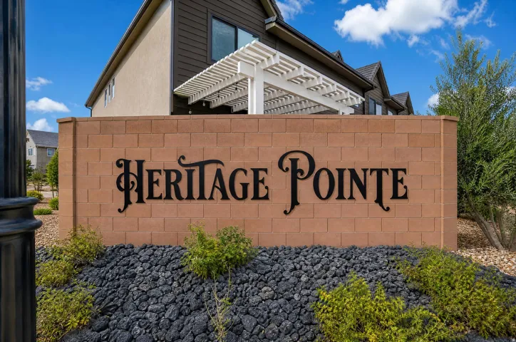 Entry monument with block construction and dimensional lettering, surrounded by plantings and decorative rock ground cover