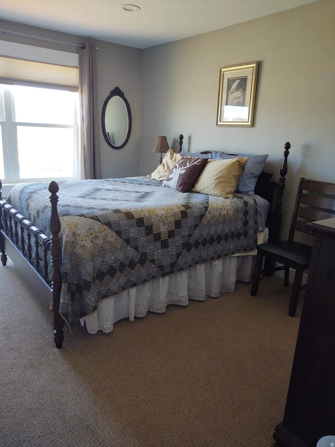 Wall-to-wall carpeting, recessed ceiling lighting, and a large window with roller shade