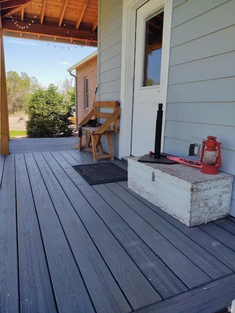 Covered porch with wood-finish decking, horizontal siding, and a wood-paneled ceiling
