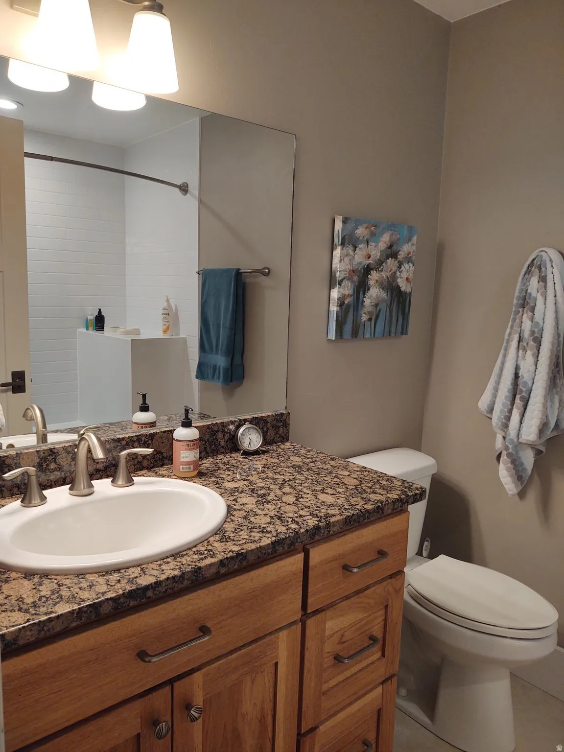 Vanity with an integrated sink, stone-finish countertop, and wood-finish cabinetry