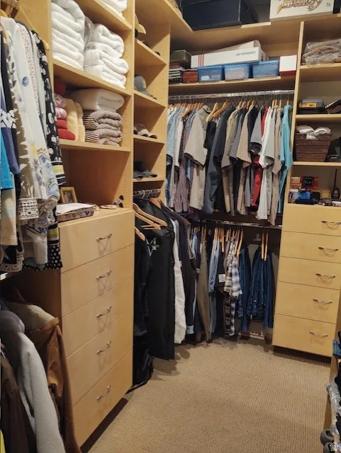 Built-in closet system with multiple shelving units, integrated drawer storage, and extensive hanging rods