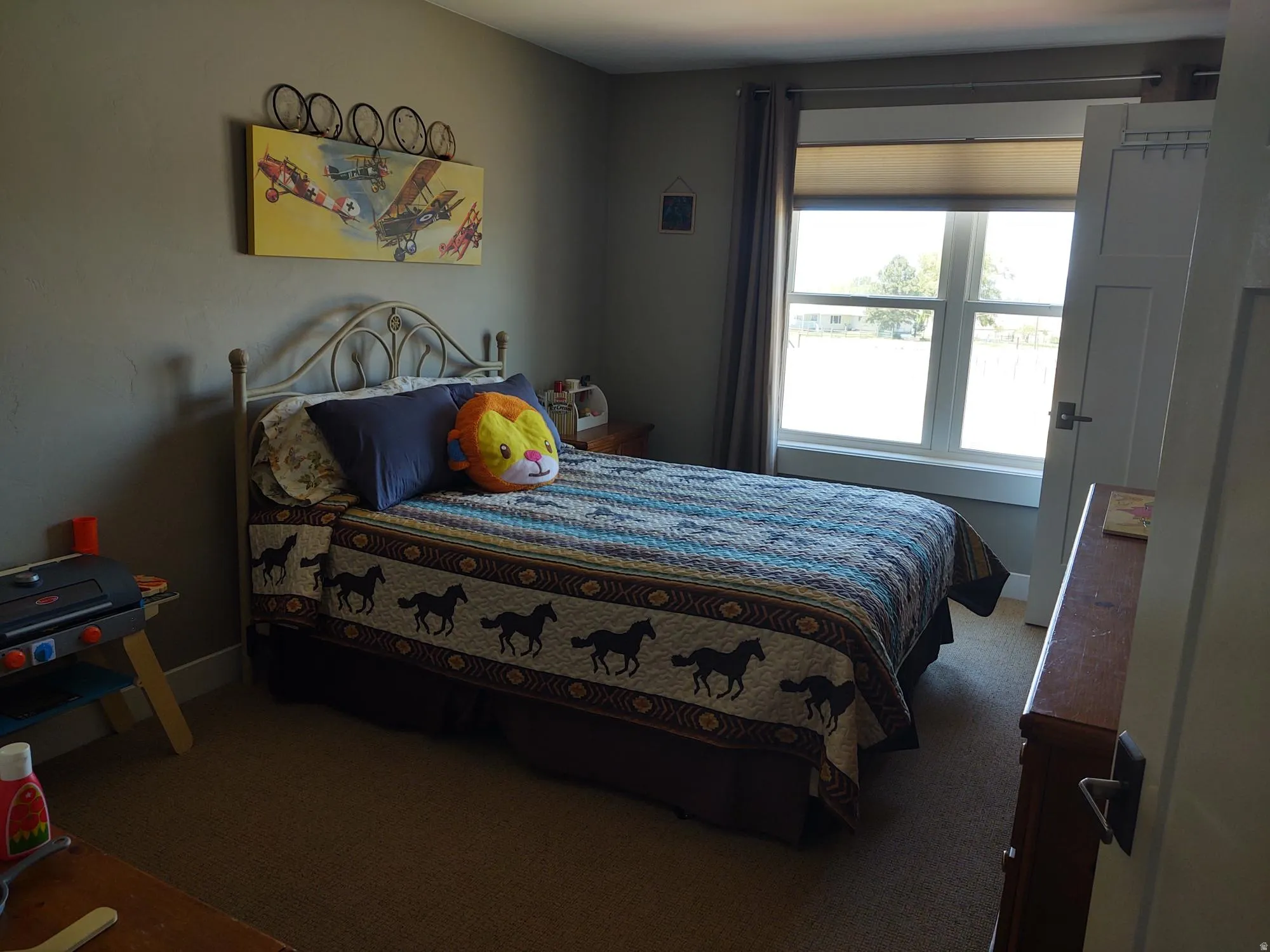 Neutral wall color, carpeted flooring, and a window with blinds