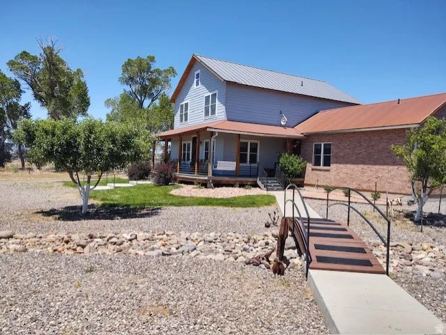 Two-story residence with a metal roof and brick-finish siding