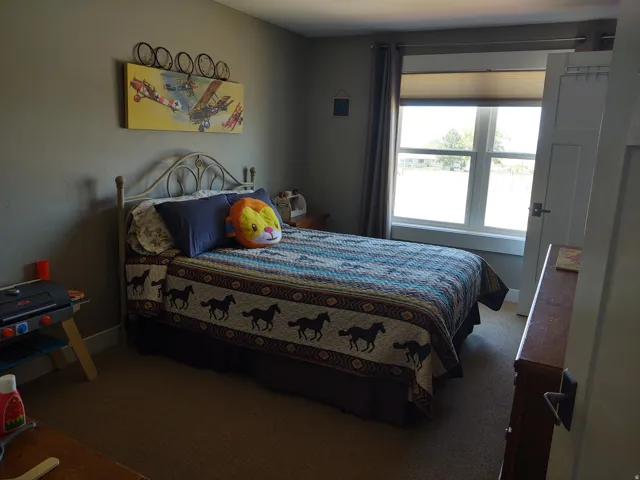Neutral wall color, carpeted flooring, and a window with blinds