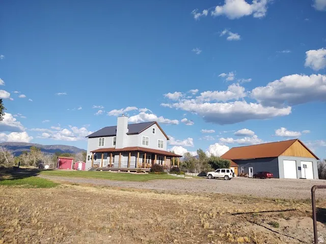 Two-story residence with a covered porch and a detached garage structure