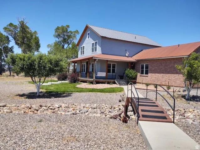 Two-story residence with a metal roof and brick-finish siding