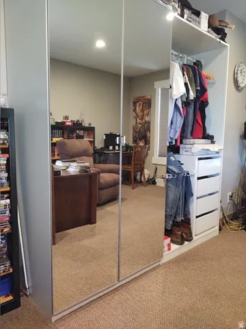 Mirrored sliding wardrobe doors with an integrated open shelving system, featuring multiple hanging rods and white drawer units