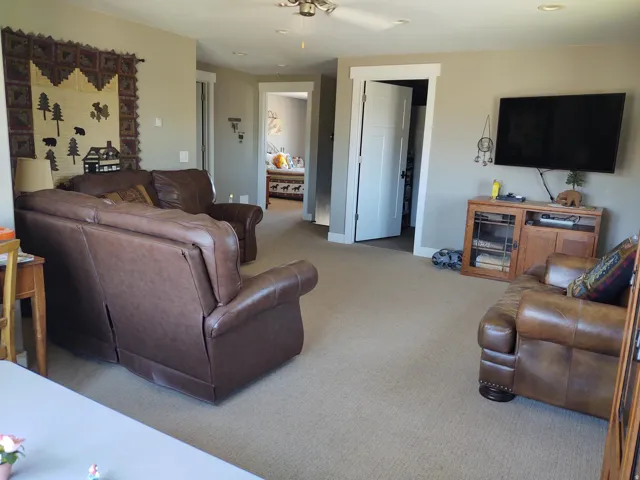 Carpeted living area featuring recessed lighting, a ceiling fan, and white trim work